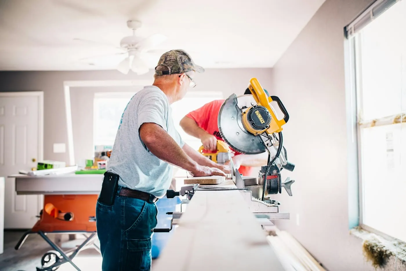 A tradesperson using a mitre saw inside a house
