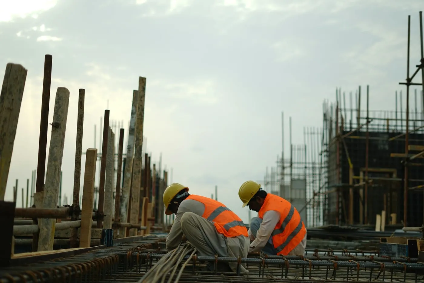 Builders in hard hats and safety vests working on a construction site